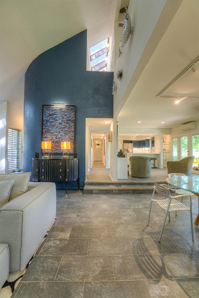 living area with a wall mounted air conditioner and stone tile flooring