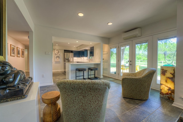 living area featuring french doors, stone tile flooring, baseboards, recessed lighting, and a wall mounted air conditioner
