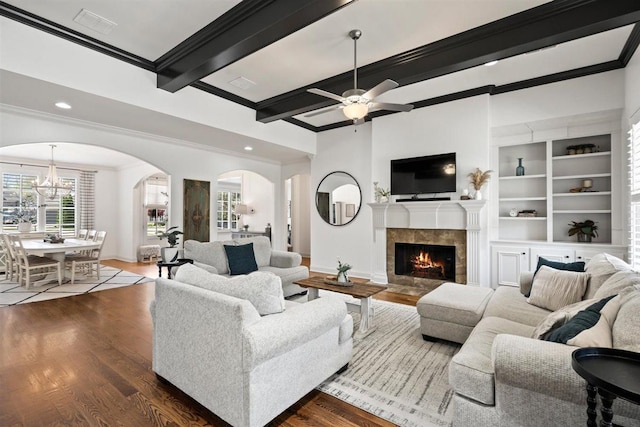 703 Justana Dr, Collierville, TN 38017 - living room featuring crown molding, arched walkways, a tile fireplace, dark wood finished floors, and baseboards