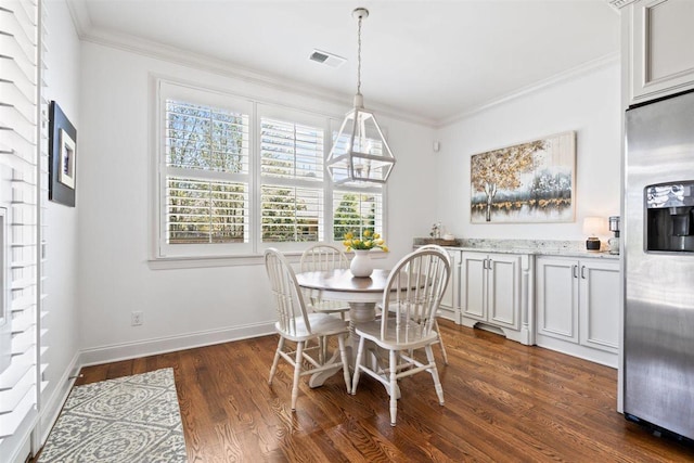703 Justana Dr, Collierville, TN 38017 - dining room featuring dark wood-style flooring, crown molding, visible vents, and baseboards