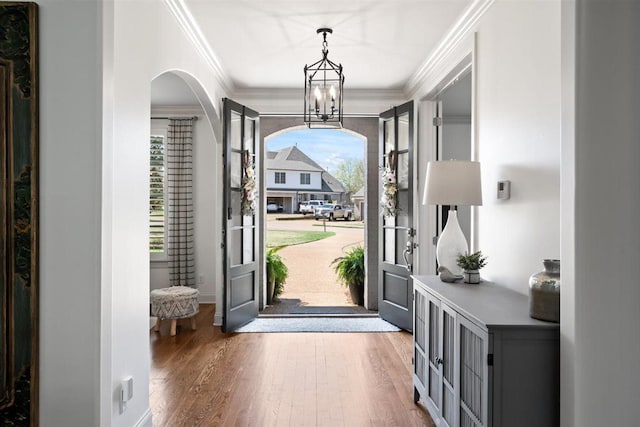 703 Justana Dr, Collierville, TN 38017 - foyer with arched walkways, wood finished floors, an inviting chandelier, and ornamental molding