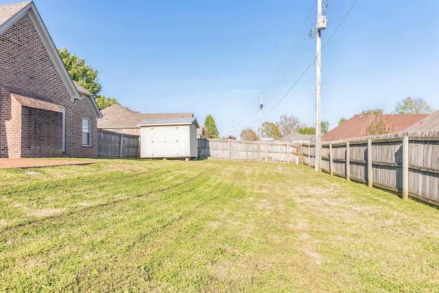view of yard with an outdoor structure, a shed, and a fenced backyard