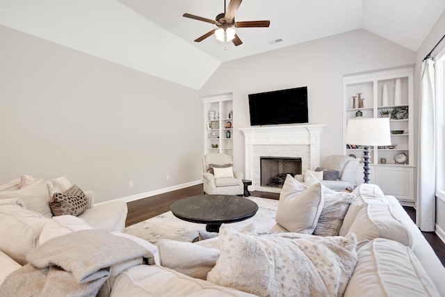 living area featuring lofted ceiling, dark wood-style floors, visible vents, a ceiling fan, and baseboards