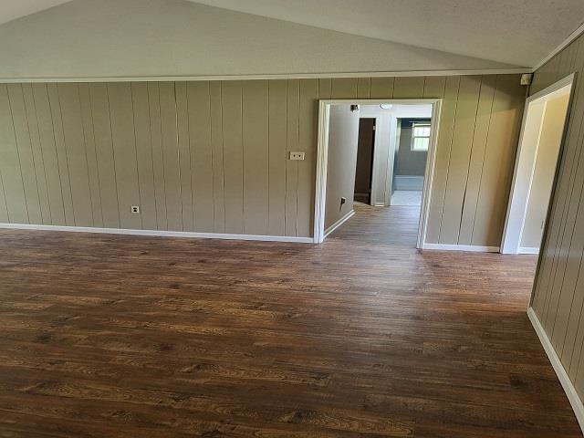3786 Brandywine Cv, Memphis, TN 38115 - unfurnished room featuring lofted ceiling, dark wood finished floors, and wooden walls