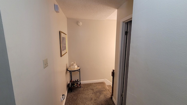 corridor with visible vents, baseboards, carpet flooring, and a textured ceiling