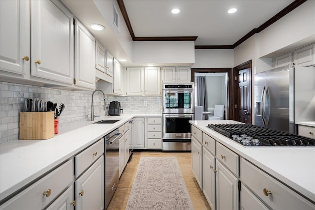 kitchen featuring stainless steel appliances, a sink, backsplash, and ornamental molding