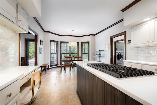 kitchen with white cabinets, light countertops, decorative backsplash, stainless steel gas cooktop, and washer / clothes dryer