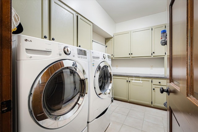 laundry room with separate washer and dryer, light tile patterned floors, and cabinet space
