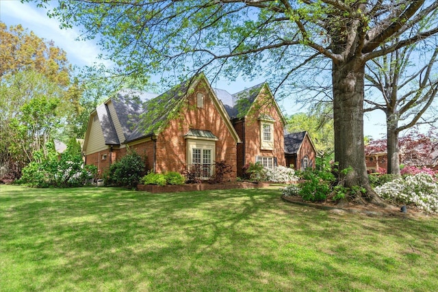 view of property exterior featuring a lawn, a shingled roof, and brick siding