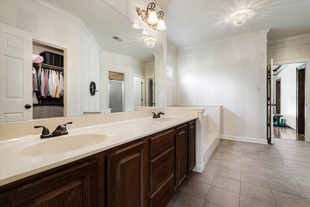 full bathroom with a shower stall, crown molding, and a sink