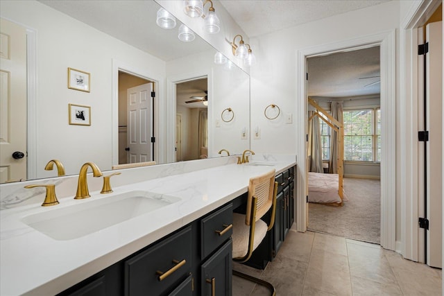 bathroom with ceiling fan, a sink, a textured ceiling, and double vanity