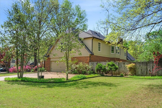 view of front of house with a front lawn, concrete driveway, fence, brick siding, and a garage