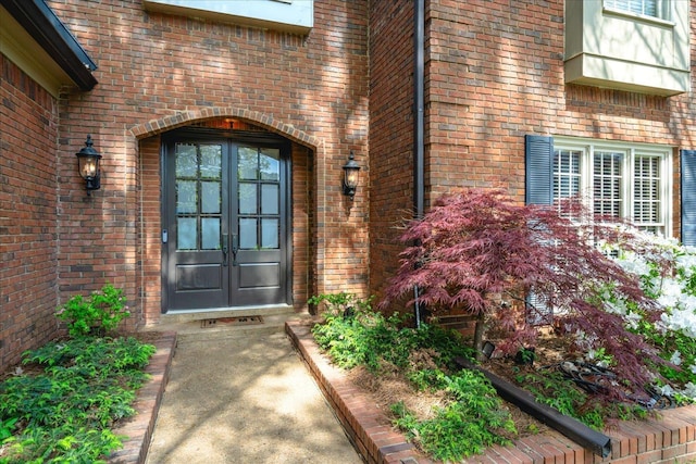 property entrance featuring french doors and brick siding