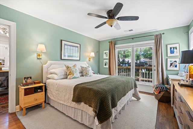 bedroom featuring visible vents, a ceiling fan, wood finished floors, and ornamental molding