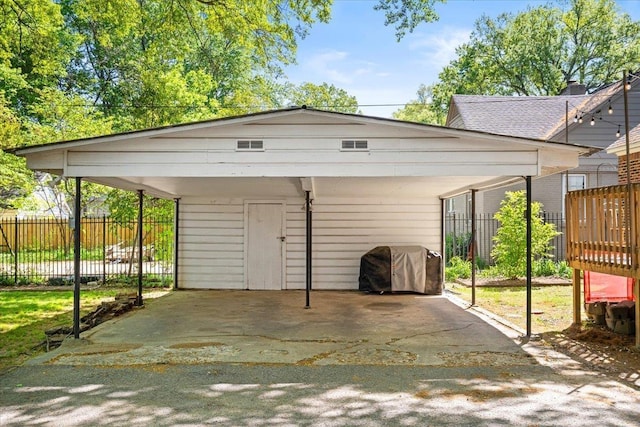 view of parking / parking lot with fence and a detached carport