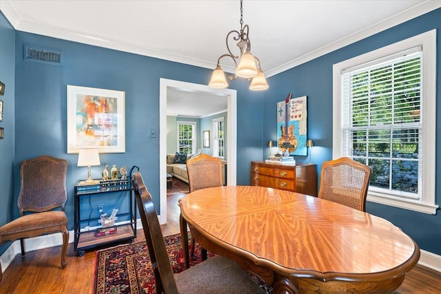 dining area with an inviting chandelier, wood finished floors, visible vents, and plenty of natural light