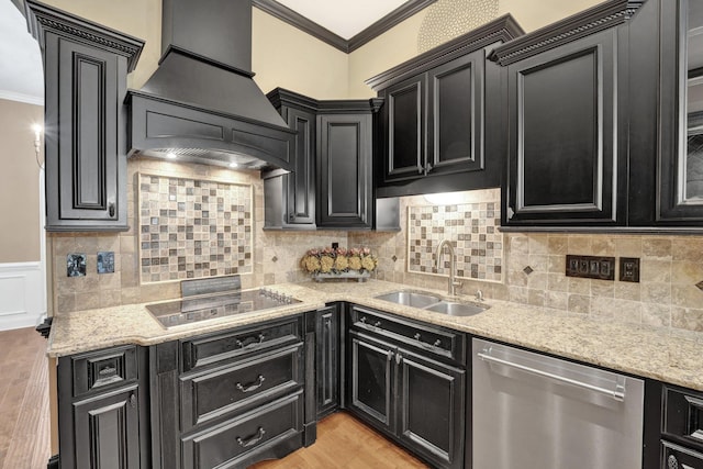 kitchen with dark cabinets, stainless steel dishwasher, a sink, and premium range hood