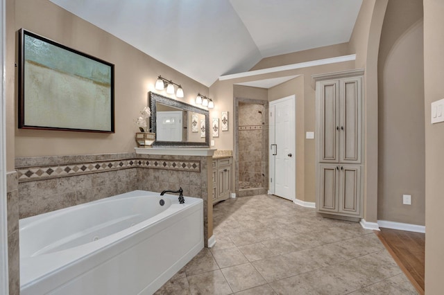 full bathroom with vaulted ceiling, a garden tub, tile patterned floors, and vanity
