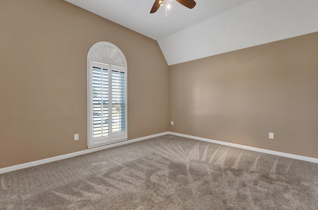 empty room featuring baseboards, vaulted ceiling, carpet flooring, and ceiling fan