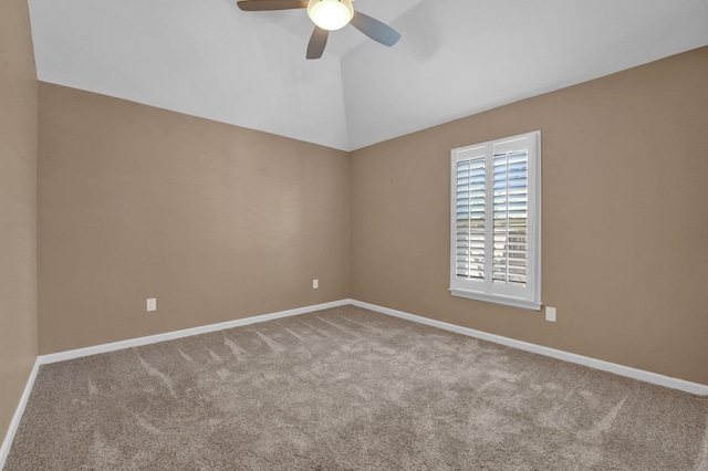 carpeted spare room featuring vaulted ceiling, a ceiling fan, and baseboards