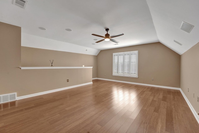 unfurnished room with vaulted ceiling, visible vents, a ceiling fan, and wood finished floors