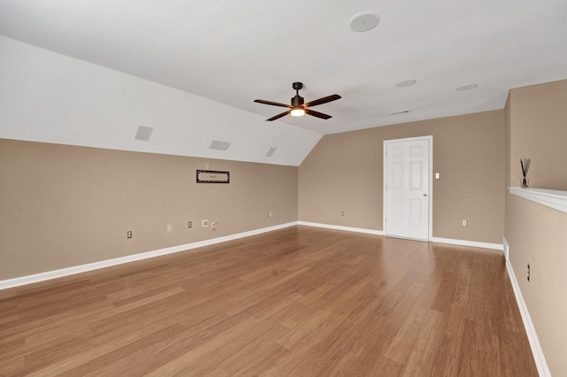 bonus room with vaulted ceiling, visible vents, light wood-style floors, baseboards, and ceiling fan