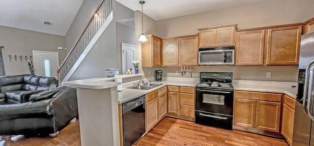 62 Mabel Ln, Atoka, TN 38004 - kitchen featuring black appliances, open floor plan, a sink, a peninsula, and light wood-style floors