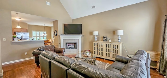 62 Mabel Ln, Atoka, TN 38004 - living room featuring wood finished floors, a tile fireplace, baseboards, and high vaulted ceiling