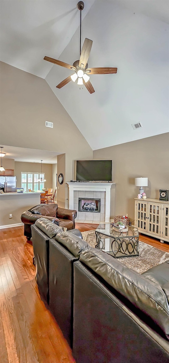 62 Mabel Ln, Atoka, TN 38004 - living area with a ceiling fan, a tiled fireplace, light wood-style floors, and high vaulted ceiling
