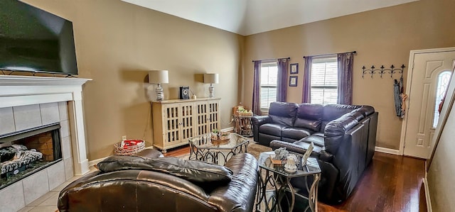62 Mabel Ln, Atoka, TN 38004 - living area featuring baseboards, a tiled fireplace, wood finished floors, and high vaulted ceiling