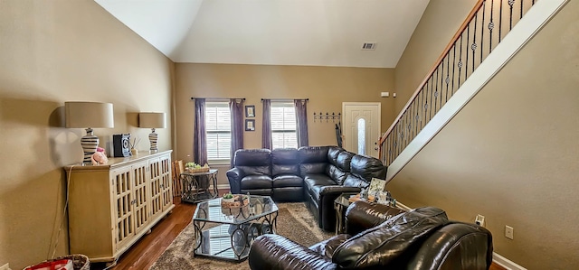 62 Mabel Ln, Atoka, TN 38004 - living room featuring dark wood-style floors, baseboards, high vaulted ceiling, and stairway