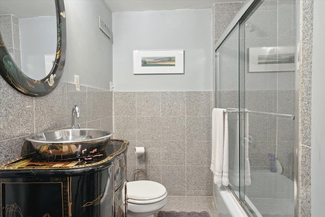 full bathroom featuring tile walls, vanity, and toilet