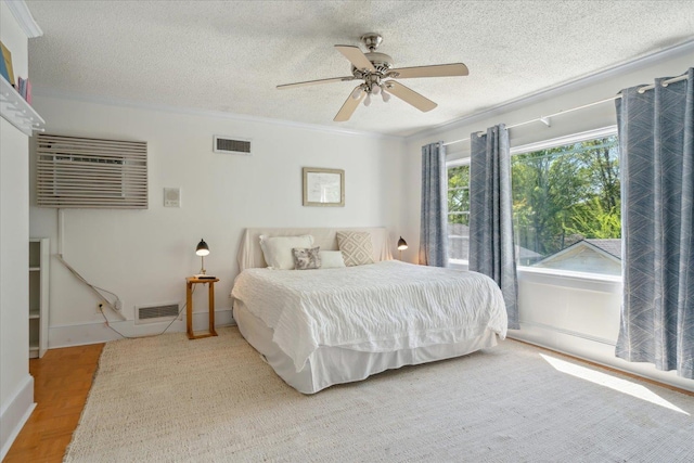bedroom with visible vents, a textured ceiling, and ornamental molding