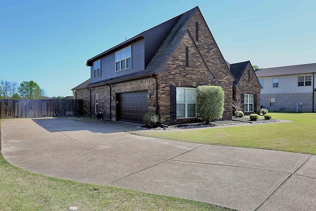 view of front facade with fence, a front lawn, driveway, brick siding, and a garage