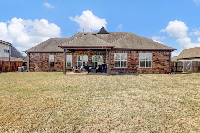 back of property featuring a shingled roof, a fenced backyard, a patio area, a lawn, and brick siding
