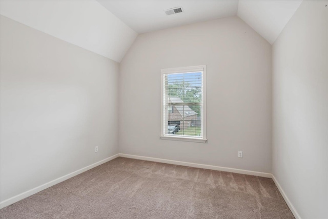 additional living space with light colored carpet, lofted ceiling, and visible vents