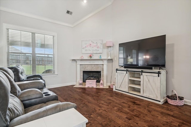 living area with vaulted ceiling, visible vents, crown molding, and wood finished floors