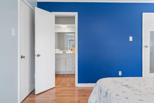 bedroom with light wood-type flooring and baseboards