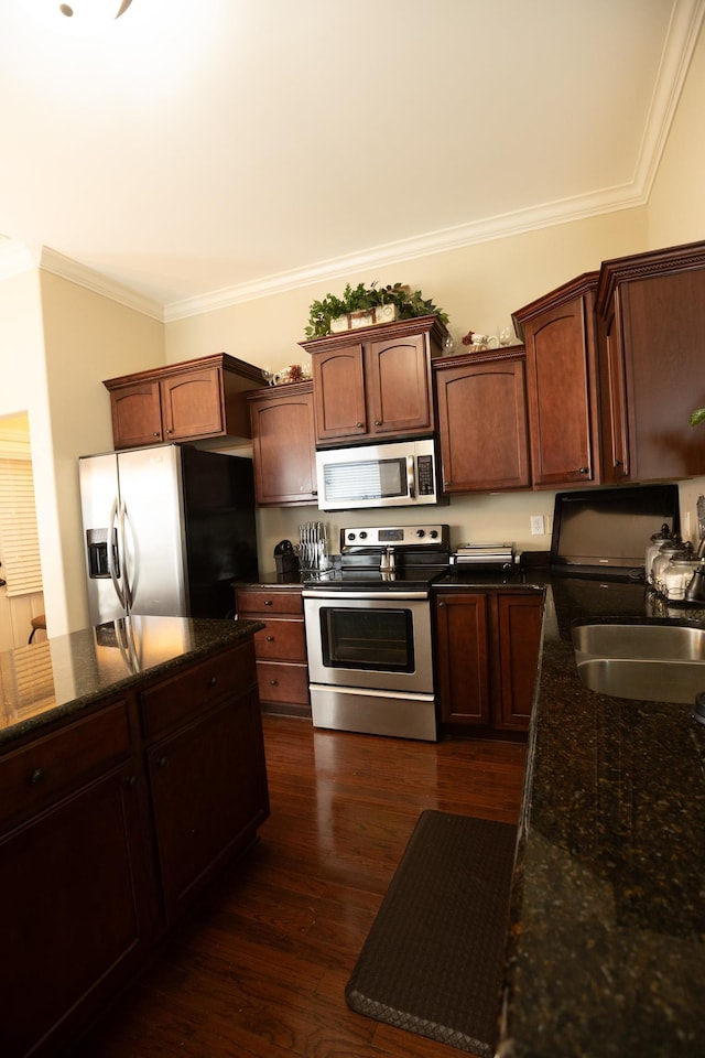 kitchen featuring stainless steel appliances, dark wood-style floors, a sink, dark stone countertops, and crown molding