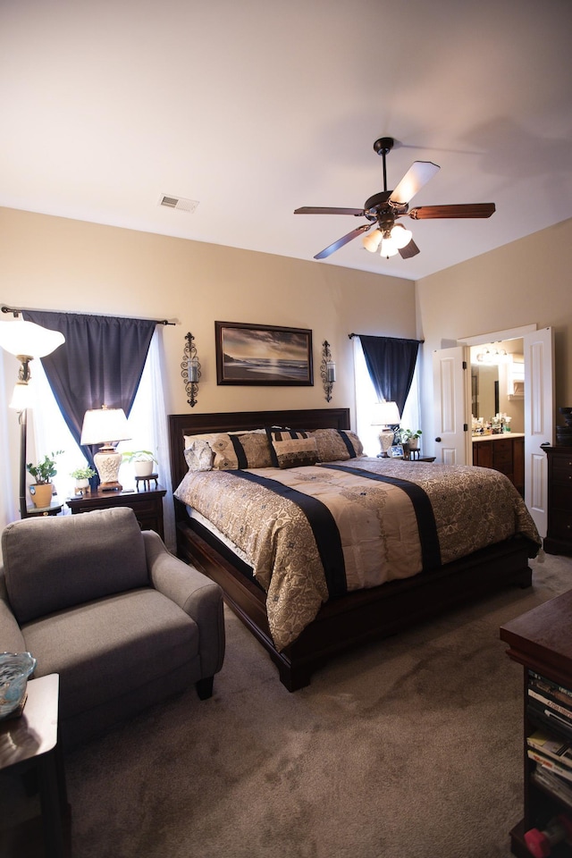 bedroom featuring visible vents, ensuite bath, carpet flooring, and ceiling fan