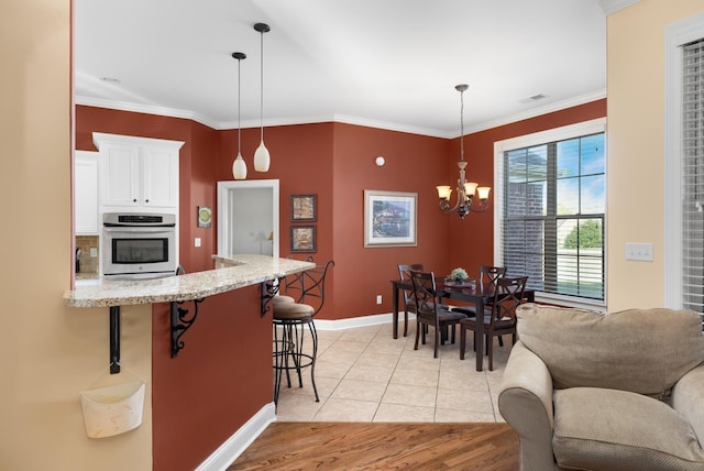 325 Fairoaks Dr, Oakland, TN 38060 - kitchen featuring white cabinets, oven, baseboards, a kitchen bar, and light stone countertops