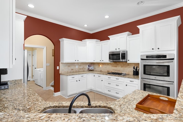 325 Fairoaks Dr, Oakland, TN 38060 - kitchen featuring a sink, tasteful backsplash, washing machine and dryer, light tile patterned flooring, and appliances with stainless steel finishes