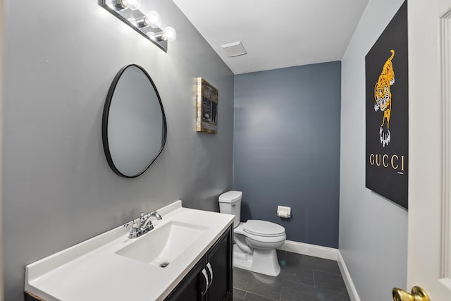 half bathroom with toilet, vanity, visible vents, and baseboards