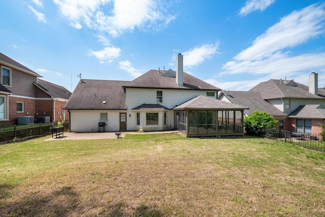 rear view of house with a yard, a sunroom, a fenced backyard, and a patio