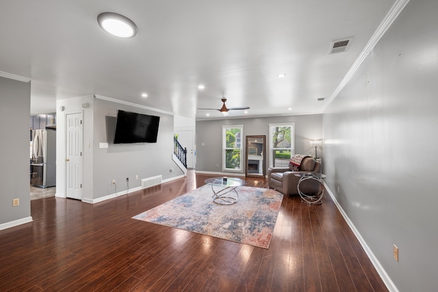 living area featuring stairway, ceiling fan, wood finished floors, and visible vents