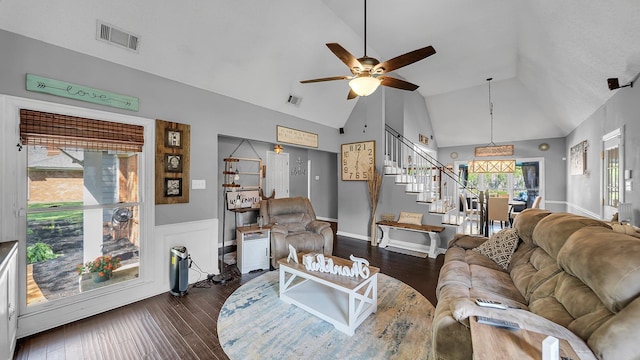 living room with lofted ceiling, visible vents, stairs, and ceiling fan