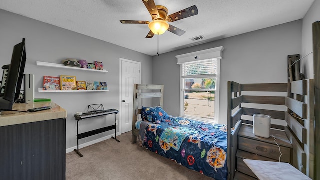 bedroom featuring carpet flooring, a textured ceiling, visible vents, baseboards, and ceiling fan