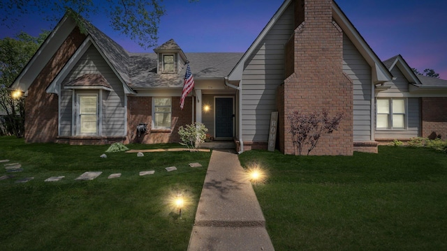 view of front facade with a front lawn and brick siding