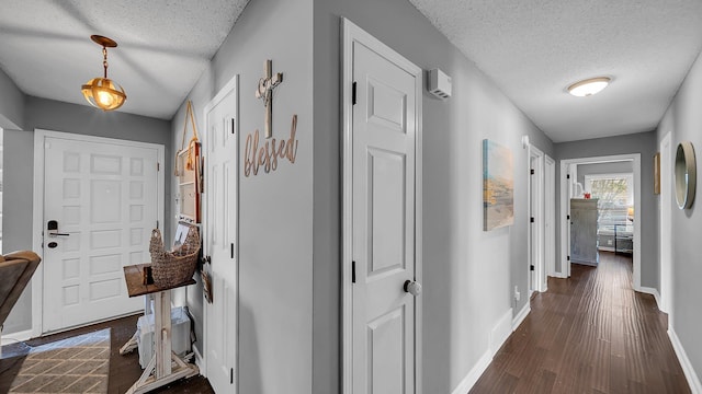 corridor with baseboards, a textured ceiling, and dark wood-style flooring