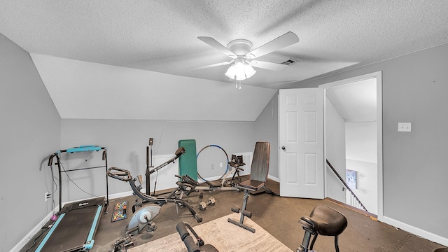 workout area featuring a textured ceiling, baseboards, visible vents, lofted ceiling, and ceiling fan